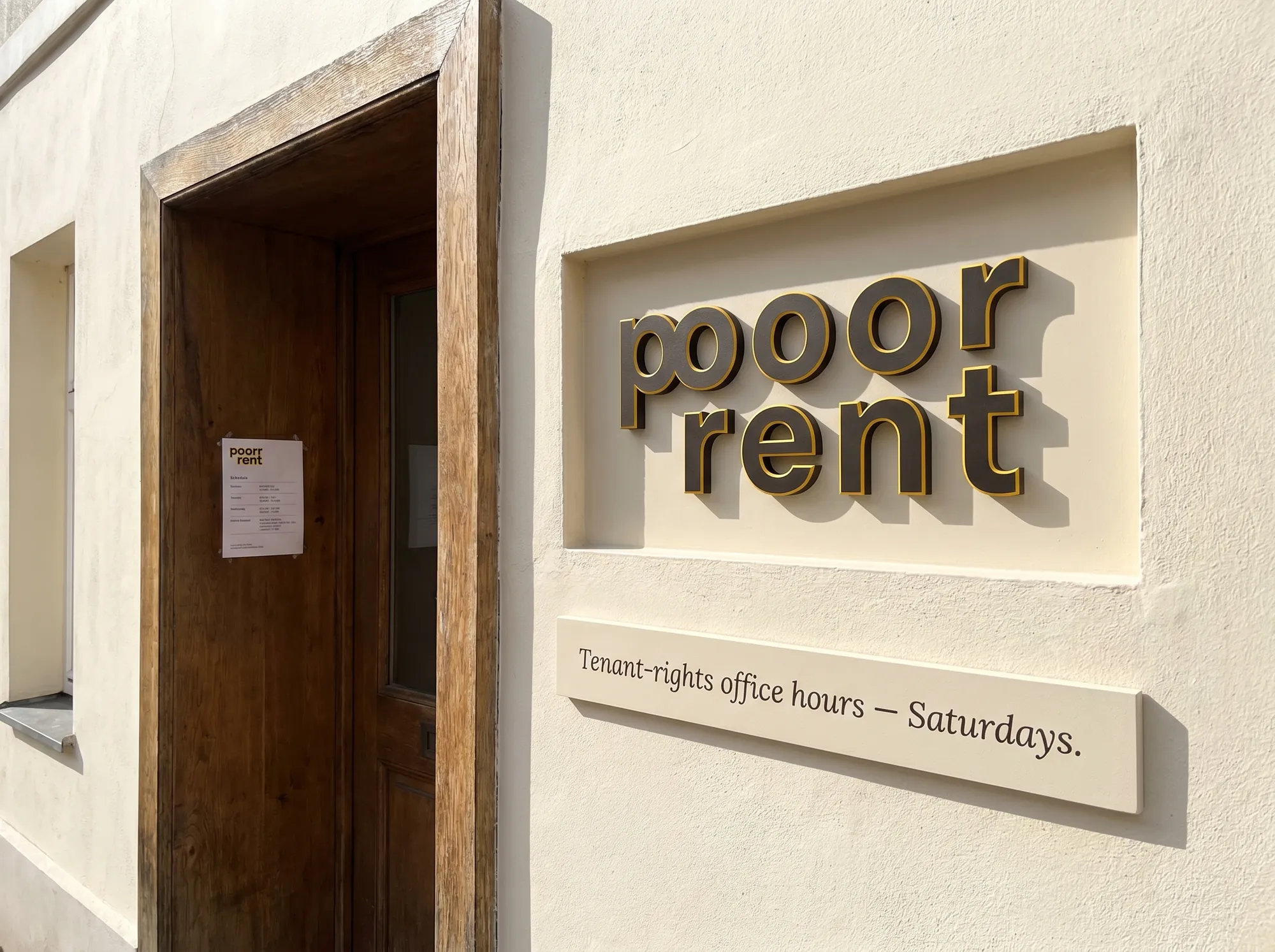 Poorr Tenant-Office Plate (Signage) — The painted-MDF wordmark plate at tenant-rights office hours hosted by Poorr — working public signage marking the legal-aid window.